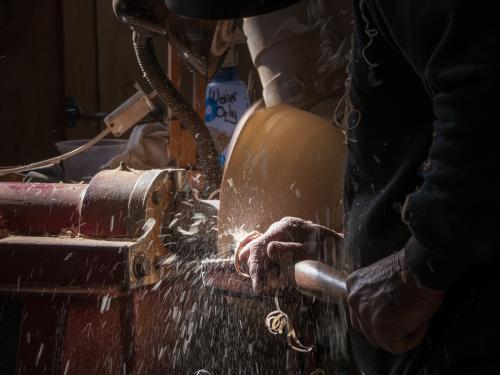 Wood turner using a lathe to make a bowl - Australian Stock Image