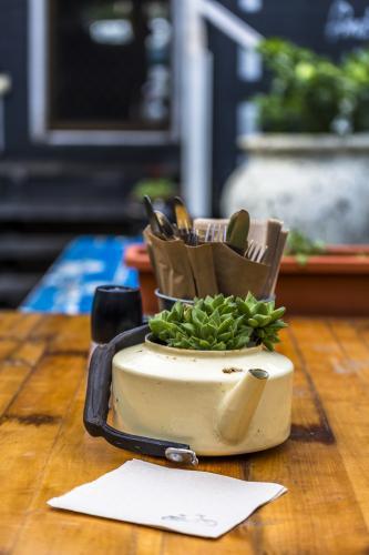 Wooden Cafe table with succulent in tea pot - Australian Stock Image