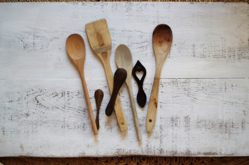 Wooden cooking spoons on white washed background - Australian Stock Image