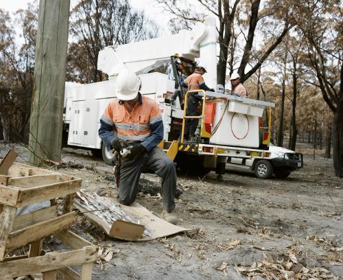 Workmen repairing power lines in bushfire ravaged landscape - Australian Stock Image