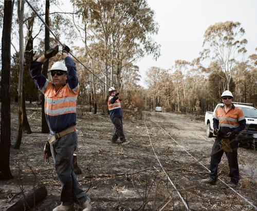 Workmen repairing power lines in bushfire ravaged landscape - Australian Stock Image