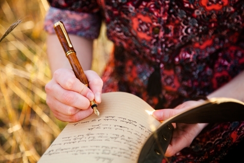 Writer holding fountain pen and notebook for writing in - Australian Stock Image