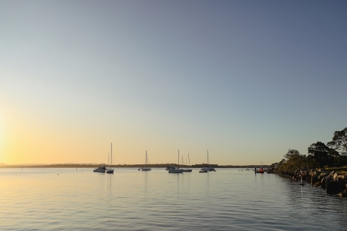 Yachts moored on the Clarence River at sunset. Iluka NSW Australia - Australian Stock Image