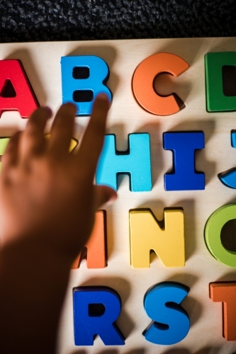 Young Aboriginal boy doing a letter puzzle - Australian Stock Image