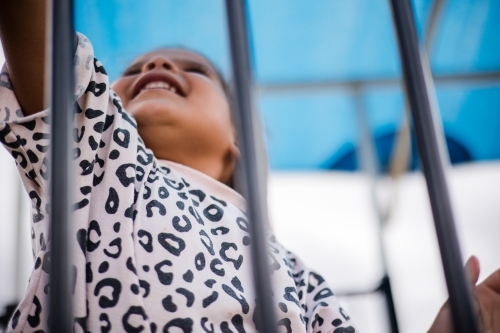 Young Aboriginal girl climbing outside at preschool