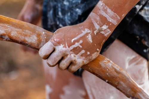 Young aboriginal persons hand holding wooden carved tool for digging and hunting - Australian Stock Image