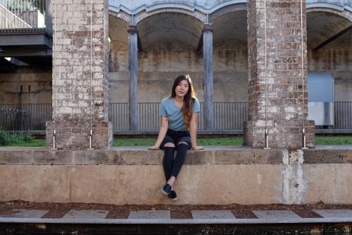 Young Asian woman enjoying time outdoors at enclave - Australian Stock Image