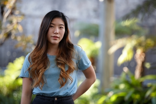 Young Asian woman enjoying time outdoors at enclave - Australian Stock Image