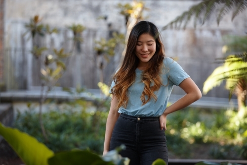 Young Asian woman enjoying time outdoors at enclave - Australian Stock Image