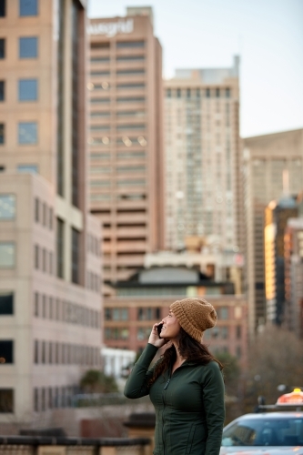 Young Asian woman on mobile phone with cityscape - Australian Stock Image