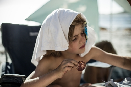 Young boy eating camping snacks - Australian Stock Image