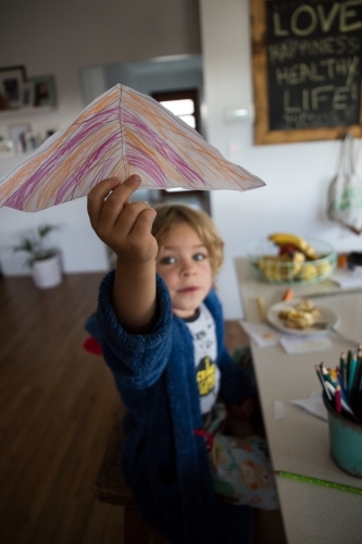 Young boy holding drawing of umbrella - Australian Stock Image