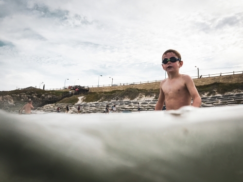 Young boy in ocean wearing goggles