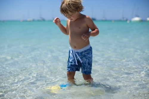 Young boy playing at beach - Australian Stock Image