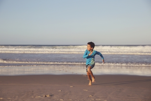 Young boy running on the beach - Australian Stock Image