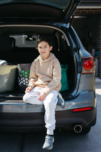 Young boy sitting in the car boot - Australian Stock Image