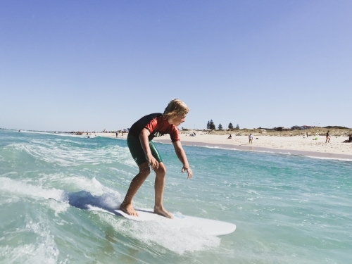 Young boy surfing a wave taken in water - Australian Stock Image