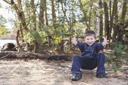 Young boy throwing sand in the air - Australian Stock Image