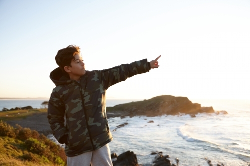 Young boy wearing camo jacket on sunrise - Australian Stock Image