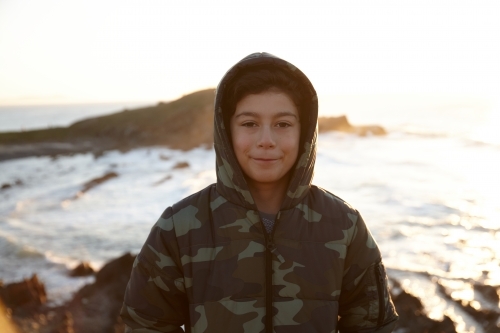 Young boy wearing camo jacket on sunrise - Australian Stock Image