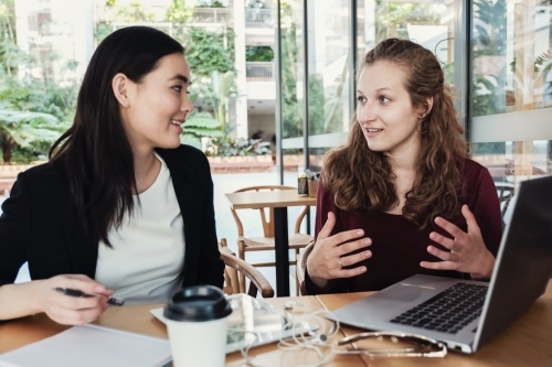 Young business women having casual meeting at coffee shop - Australian Stock Image