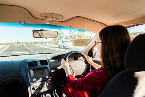 Young driver driving right hand drive car in Australia - Australian Stock Image