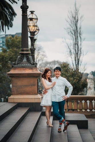 Young engaged couple embracing on the steps of the Old Treasury Building in Melbourne - Australian Stock Image