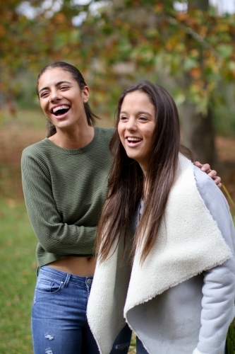 Young female couple laughing in an outdoor setting - Australian Stock Image