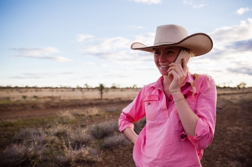 Young female farmer talking on smart phone - Australian Stock Image