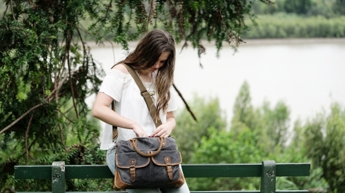 Young female student looking through bag - Australian Stock Image