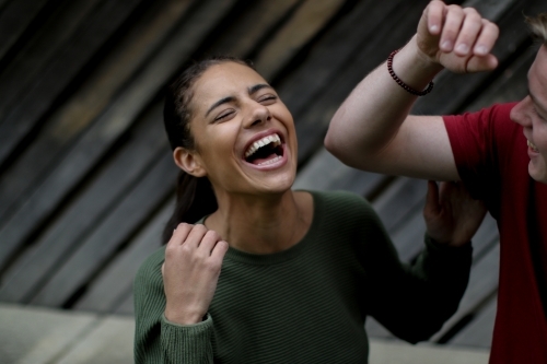 Young Fijian woman throwing head back with laughter - Australian Stock Image