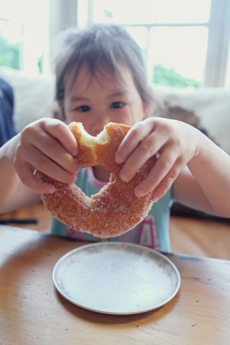 Young girl holding a doughnut - Australian Stock Image