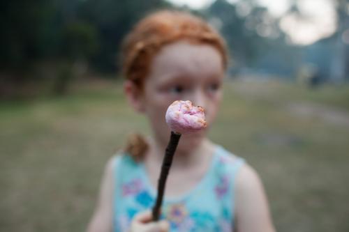 Young girl holding a toasted marshmallow - Australian Stock Image