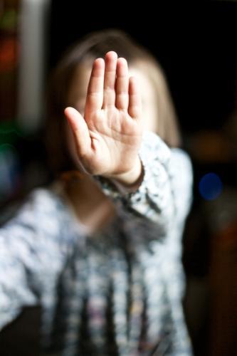 Young girl holding her hand up to say stop - Australian Stock Image