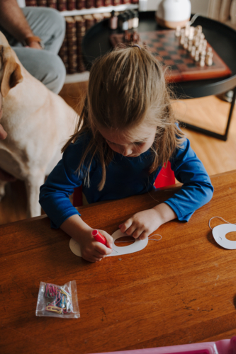 Young girl in superhero costume colouring her mask. - Australian Stock Image