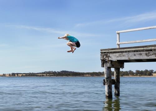 Young Girl Jumping off a Jetty - Australian Stock Image