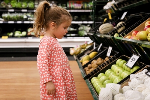 Young Girl looking at Fruits in Supermarket - Australian Stock Image