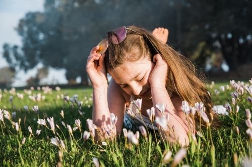 Young girl lying in grass and flowers