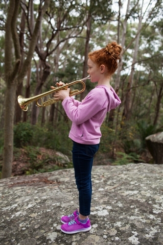 Young girl playing a trumpet outside - Australian Stock Image