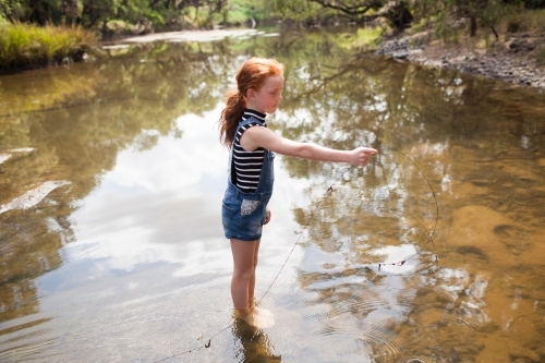 Young girl playing in the river