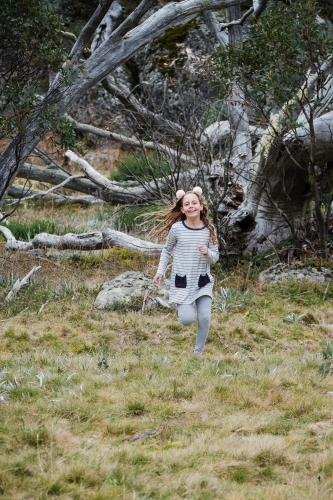Young girl runs in the country side. - Australian Stock Image
