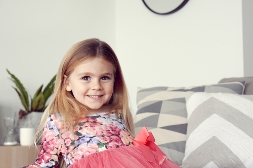 Young girl sitting down inside - Australian Stock Image