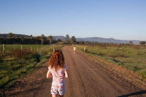 Young girl walking along a dirt rural road