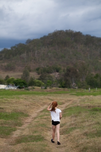 Young girl walking along a dirt track - Australian Stock Image