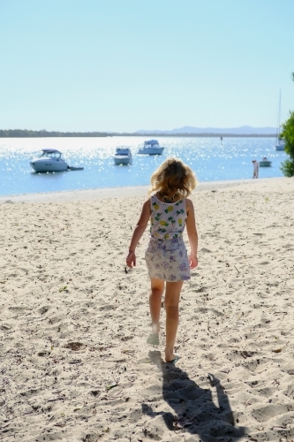 Young girl walking towards the beach - Australian Stock Image