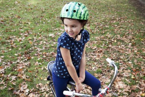 Young girl wearing helmet and sitting on bike