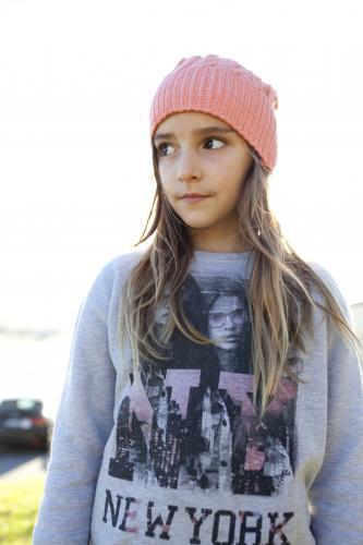 Young girl with beanie on looking away in afternoon light - Australian Stock Image