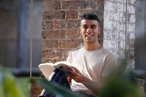 Young Indigenous Australian man enjoying time outdoors with his book