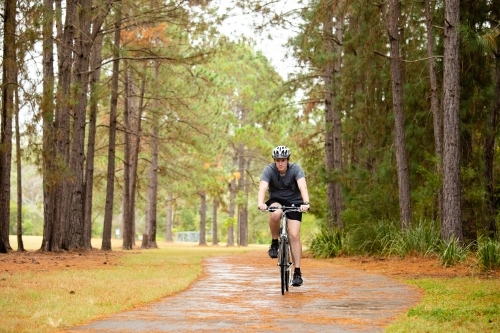 Young male cycling along a parkland bike path - Australian Stock Image
