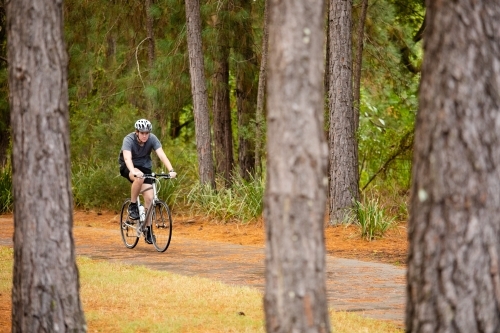 Young male cycling along a parkland bike path - Australian Stock Image